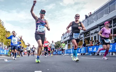 Glada löpare i BMW Berlin Marathon. Petra, med nummer 24287, firar sin framgång. En härlig dag för runners world triathlon.
