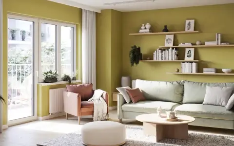 Jasnozielone ściany w salonie, jak sprawdzić kolor farby na ścianie? Wygodna kanapa, fotel i stolik kawowy.