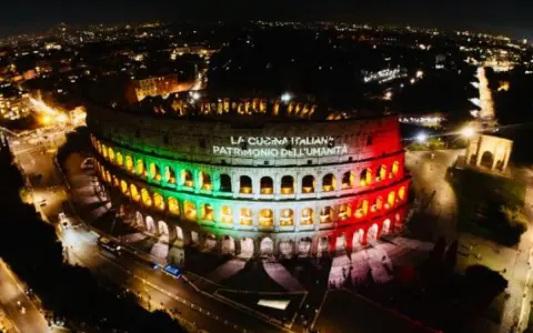 Il Colosseo illuminato di notte con i colori della bandiera italiana, celebra "La Cucina Italiana Patrimonio dell'Umanità", un riconoscimento che il Colosseo, patrimonio dell'UNESCO, merita.