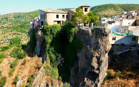 Casas aferradas a un acantilado, con vegetación cubriendo la roca. El mirador de la Molatica ofrece vistas espectaculares del paisaje.