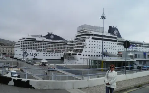Donna in piedi davanti a due navi MSC in attesa dell'imbarco a Genova per Portofino.