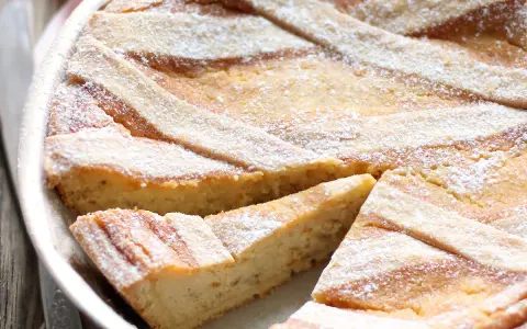 Pastiera napoletana con pasta frolla, un dolce tradizionale. La sua crosta dorata e le strisce di frolla invitano ad assaggiarla.