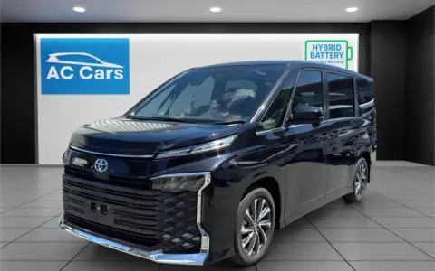 Czarny minivan Toyota Voxy stoi w salonie samochodowym AC Cars.