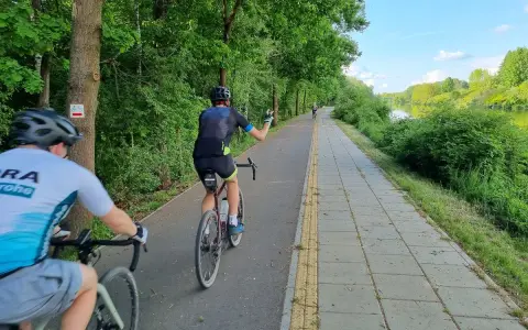 Rowerzyści na malowniczych trasach rowerowych w Warszawie, wzdłuż rzeki.