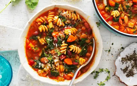 Aksamitna zupa minestrone z makaronem, fasolą i warzywami, posypana parmezanem. Idealna na chłodne dni.