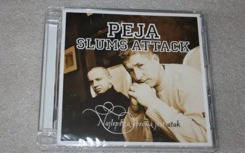 Okładka płyty "Peja Slums Attack - Najlepsza obrona jest atak". Dwóch mężczyzn, jeden w czarnym golfie, drugi w swetrze, spogląda wprost na widza.