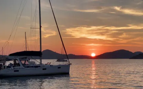 Voiliers au coucher du soleil, une scène paisible pour apprendre comment mouiller rapidement.