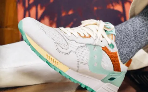 Zapatillas Saucony con detalles en menta y naranja. Consulta la **guía de tallas Saucony** para encontrar tu ajuste perfecto.