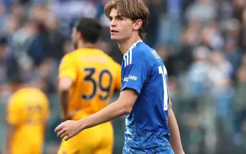 Joven futbolista Nico Paz, con el dorsal 10 en su camiseta azul, mira atentamente el partido.