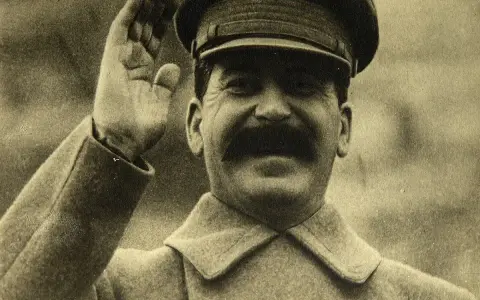 Józef Stalin w mundurze, salutujący. Jego śmierć, na co zmarł Stalin, wciąż budzi dyskusje.