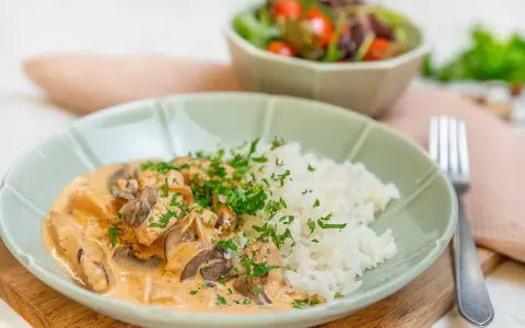 En krämig kyckling stroganoff med champinjoner och ris, toppad med persilja. En härlig middag!