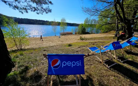 Słoneczny dzień nad jeziorem, leżaki z logo Pepsi czekają na gości turawa camp.