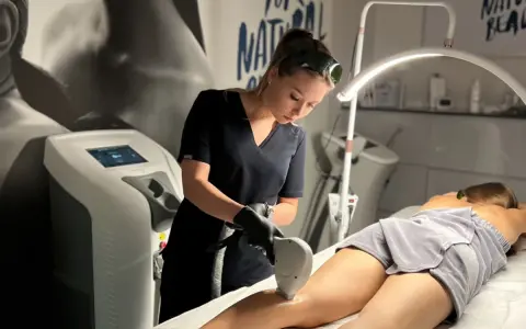 Profesjonalistka wykonuje zabieg depilacji laserowej nogi. To najlepszy laser do depilacji, zapewniający gładkość skóry.