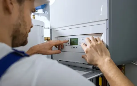 Un technicien ajuste les réglages d'une chaudière fioul qui démarre puis s'arrête.