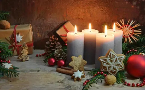 Vier brennende Kerzen im **Hintergrund Adventszeit**, umgeben von Tannenzweigen, Geschenken, Nüssen und Weihnachtsplätzchen.