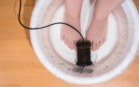 Feet in a detox foot bath with an ionizer. This setup is often used in a detox foot bath recipe for relaxation and cleansing.