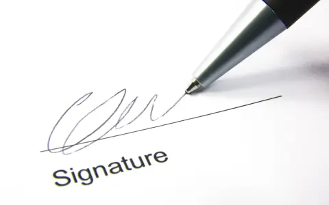 A pen signs a document, finalizing a corporate sponsorship agreement.