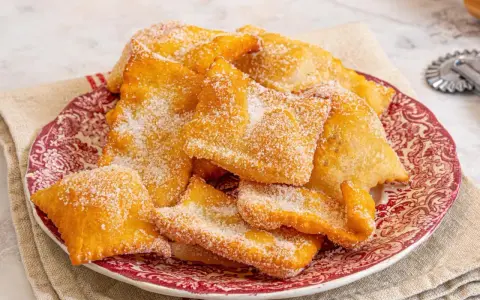 Deliciosas hojuelas fritas espolvoreadas con azúcar, como si fueran miel sobre hojuelas. Un postre crujiente y dulce.