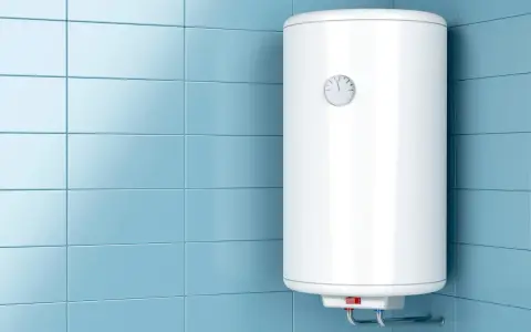 Scaldabagno bianco su parete piastrellata azzurra. Potrebbe essere necessario uno smaltimento caldaia superbonus per questo modello obsoleto.