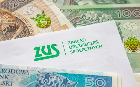 Koperta z logo ZUS leży na stosie polskich banknotów. z15b druk.
