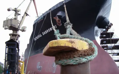 Gros plan sur une aussière, définition de l'amarrage d'un navire, le "GENERAL DABROWSKI", au port. Grues et échafaudages en arrière-plan.