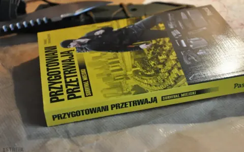 Książka "Przygotowani przetrwają. Survival miejski" leży obok noża. Podręcznik do przetrwania w miejskiej dżungli.