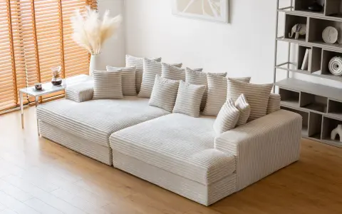 Canapé modulable blanc côtelé, parfait pour un salon cosy. Sa faible hauteur le rend idéal pour un espace moderne.