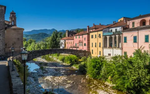 Pontremoli, dove si trova questo pittoresco borgo con case colorate, un ponte ad arco e un fiume.