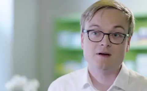 Mann mit Brille spricht über seine bretaris genuair erfahrungsberichte.