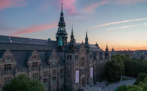 Nordiska museet badar i solnedgångens rosa sken.