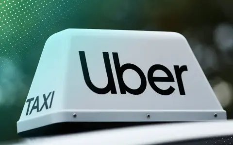 Uber Taxi-Schild auf einem Auto. Werden Sie jetzt Uber Partner und starten Sie Ihre Karriere!