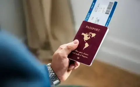 Dłoń trzyma paszport i bilet lotniczy. Planujesz podróż i zastanawiasz się, czy Cypr jest w Schengen?