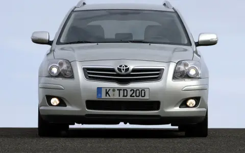 Srebrny Toyota Avensis T25 z włączonymi światłami mijania i przeciwmgielnymi, gotowy do podróży.