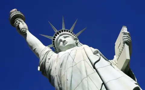 La Statue de la Liberté, une femme emblématique, lève sa torche vers le ciel. Elle porte une tablette, symbole de la loi.