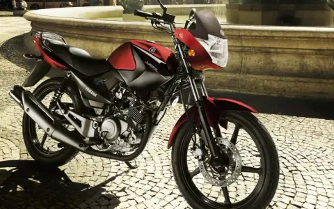 Czerwony motocykl Yamaha YBR 125 na brukowanej ulicy. Sprawdź yamaha ybr 125 dane techniczne, by poznać jego możliwości.