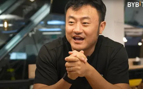 Ben Zhou, w czarnej koszulce, z dłońmi złożonymi na piersi, opowiada o przyszłości kryptowalut.