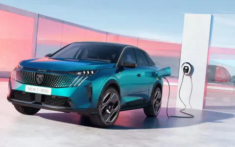Un nuevo Peugeot E-3008 eléctrico enchufable, de color azul turquesa, cargando en un moderno punto de recarga.