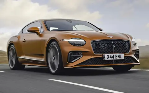 Pomarańczowy Bentley Continental GT na drodze. Sprawdź aktualną bentley cena i poczuj moc.