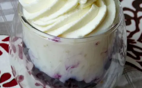 Délicieuse mousse chocolat blanc aérienne, parsemée de fruits rouges, servie dans un verre.