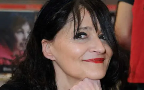 Portrait de Miss.Tic, artiste urbaine dont le décès a marqué le monde de l'art. Son regard pétillant et son sourire énigmatique restent gravés.