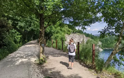Ścieżka w kamieniołomie Liban, idealne miejsce, gdzie na spacer w Krakowie. Kobieta z plecakiem idzie w stronę skalistych zboczy.