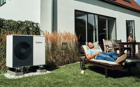 Pompa di calore Vaillant, silenziosa e discreta, permette a un uomo di rilassarsi in giardino senza sentire alcun rumore strano.