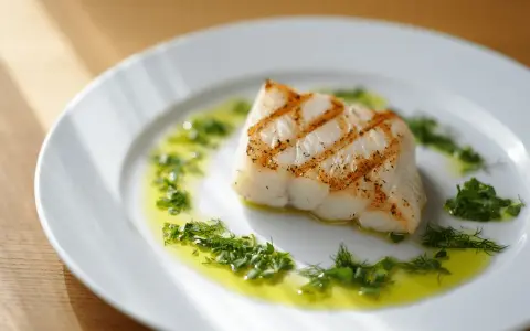 Un delicioso bacalao a la plancha, con marcas doradas y servido sobre un plato blanco con aceite de oliva y hierbas frescas picadas.