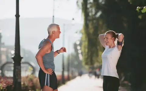 Coppia che discute a che ora andare a correre in un parco soleggiato.