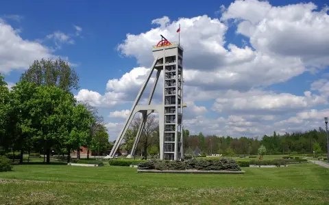 Betonowy szyb górniczy, dawniej szyb prezydent, góruje nad zielonym parkiem.