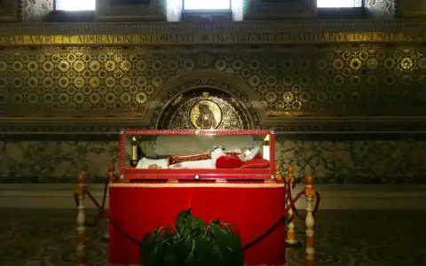 Relikwie papieża, najdłużej panującego, w szklanej trumnie. Złote mozaiki i marmury zdobią wnętrze.
