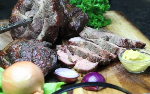Saftiger Mutzbraten, frisch aufgeschnitten, mit Senf, Zwiebeln und Petersilie. Ein tolles Rezept für den Grill.