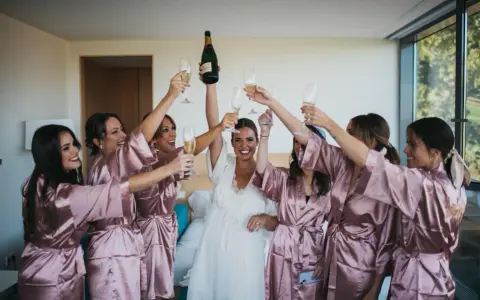 Novia y damas de honor brindan con champán, ¡ideas para despedidas llenas de alegría y celebración!