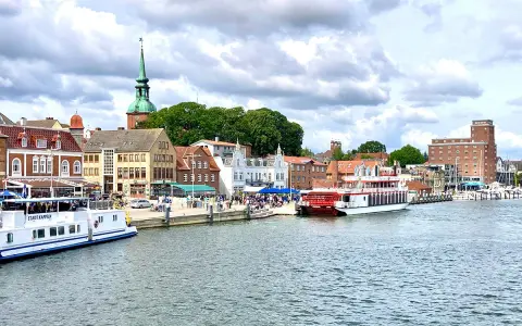Hafen von Kappeln mit Schiffen und historischen Gebäuden. Entdecken Sie die Kappeln Geheimtipps für Ihren nächsten Urlaub.