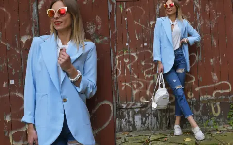Kobieta w błękitnej marynarce i podartych jeansach prezentuje stylowe stylizacje. Okulary przeciwsłoneczne dodają charakteru.